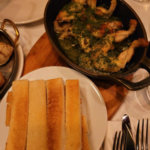 Traditional French escargot served in garlic butter with shells on a metal plate