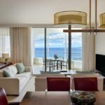 luxury suite showing living room and balcony with ocean view